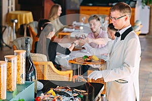 The waiter shifts the seafood on a tray in the restaurant.