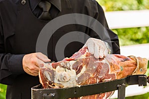 Waiter slicing italian ham, prosciutto