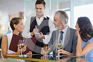 Waiter taking the order from a businessman and his colleagues