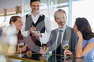 Waiter taking the order from a businessman and his colleagues