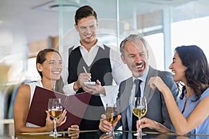 Waiter taking the order from a businessman and his colleagues