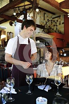 Waiter talking to costumer at the restaurant photo