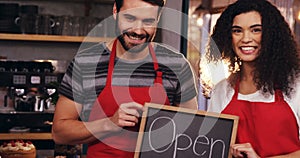 Waiter and waitress showing slate with open sign