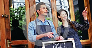 Waiter and waitresses standing with menu board