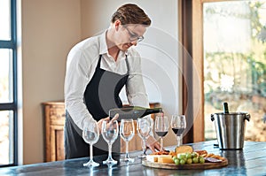 Waiter, wine tasting, and bartender with glass at fine dining vineyard restaurant in countryside. Professional sommelier