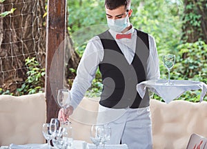 The waiter works in a restaurant on the summer terrace