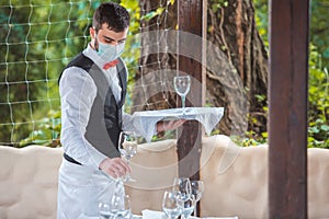 The waiter works in a restaurant on the summer terrace