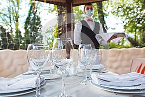 The waiter works in a restaurant on the summer terrace