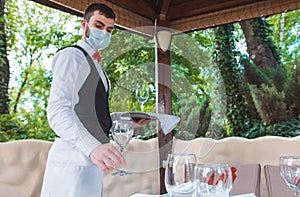 The waiter works in a restaurant on the summer terrace