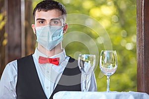 The waiter works in a restaurant on the summer terrace