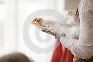 Waiters carrying plates with meat dish at a wedding