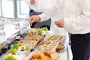 Waiters serving buffet canapes on table. Food and celebration concept