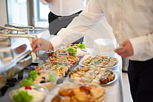 Waiters serving buffet canapes on table. Food and celebration concept