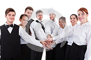 Waiters and waitresses stacking hands