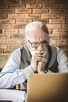 Waiting answer. Mature man working on computer.
