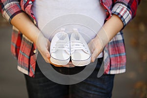 Waiting of baby-boy. Little white baby`s bootees in mom`s and da`s hands.