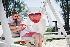 Waiting baby. pregnant woman with beloved husband sit on a bench. Husband hand embraces a round belly wife. Parenthood