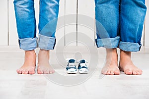 Waiting of baby. Pregnant woman, pregnancy, motherhood. Happy family. Mom`s, Dad`s and baby`s bootees. Family look