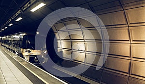 Waiting in beautiful railway station tunnel stop no train at arriving Heathrow airport, London. Railroad with vintage toning for t