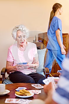 Waiting for the next move. seniors playing cards in their retirement home.