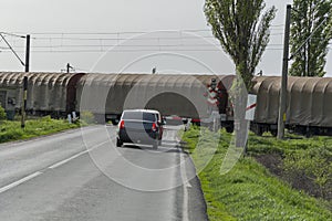 Waiting at a railroad crossing while a freight train passes by