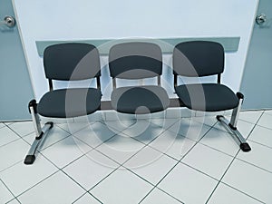 waiting room with light blue walls, white floor and comfortable chairs in dark blue