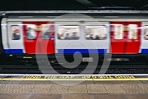 Subway train at the station from the platform seeing the Mind the Gap letters