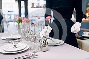 Waitress against empty tableware, table setting
