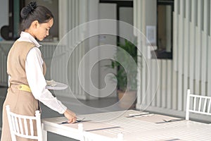 Waitress asian against empty tableware, table setting