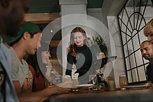 Waitress bringing customers drinks in a bar at night