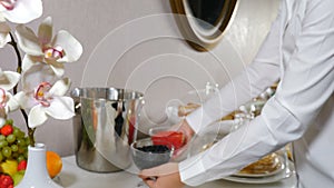 Waitress brings dishes with red and black caviar to the served table for guests. Preparing for banquet. open buffet in