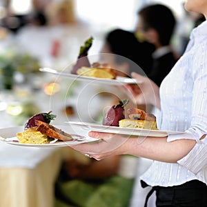 Waitress is carrying three plates