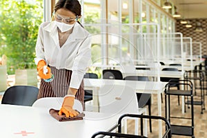 Waitress cleaning table, New Normal Restaurant concept