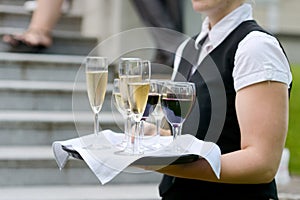 Waitress with dish of champagne glasses