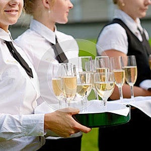 Waitress with dish of champagne glasses