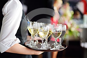 Waitress with dish of champagne and wine glasses