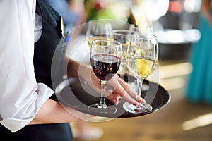 Waitress with dish of champagne and wine glasses