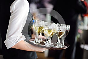 Waitress with dish of champagne and wine glasses