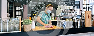 Waitress disinfecting bar counter due to coronavirus