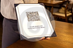 Waitress display contactless menu with QR code as part of new normal. Dummy QR Code Used