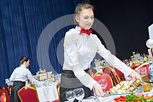 Waitress on duty serving banquet table