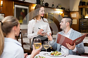 Waitress and guests in cafe