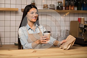 Waitress holding coffee to go and take away food in cafe