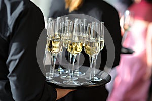 Waitress holding a dish of champagne and wine glasses