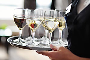 Waitress holding a dish of champagne and wine glasses at festive event