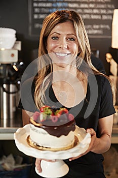 Waitress Holding Freshly Baked Cake With Buttercream Frosting