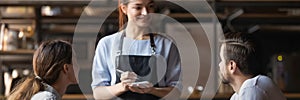 Waitress holding notepad ready take restaurant visitors couple order