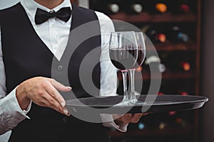 Waitress holding a tray with glasses of red wine