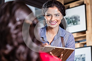 Waitress in indian restaurant taking orders