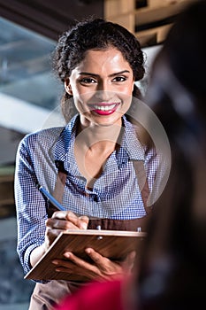 Waitress in indian restaurant taking orders